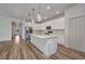Open-concept kitchen with stainless steel appliances, quartz counters, and hardwood floors at 16848 Canopy Garden Dr, Port Charlotte, FL 33953