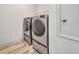 Modern laundry room with new front load washer and dryer units and vinyl flooring at 16848 Canopy Garden Dr, Port Charlotte, FL 33953