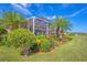 Professionally landscaped backyard with a screened-in patio and lake view at 1775 Scarlett Ave, North Port, FL 34289