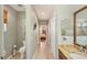 Neutral hallway leads to a bedroom and bathroom with warm tile floors and light paint at 1775 Scarlett Ave, North Port, FL 34289
