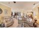Bright living room flowing into kitchen area featuring neutral tones, tile flooring, and comfortable seating at 1775 Scarlett Ave, North Port, FL 34289