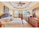 Bright main bedroom featuring a tray ceiling, wood floors, and shutters on the windows at 1775 Scarlett Ave, North Port, FL 34289