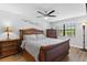 Comfortable bedroom featuring a wooden sleigh bed, neutral walls, ceiling fan, and natural light from the window at 19505 Quesada Ave # Vv201, Port Charlotte, FL 33948