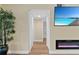 Bright hallway featuring wood floors, fireplace, TV, and an opening to another room at 19505 Quesada Ave # Vv201, Port Charlotte, FL 33948
