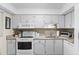 Well-lit kitchen features white cabinetry and granite countertops offering a bright and functional cooking area at 19505 Quesada Ave # Vv201, Port Charlotte, FL 33948