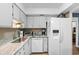 White kitchen with stainless steel sink and modern appliances for a clean and bright culinary space at 19505 Quesada Ave # Vv201, Port Charlotte, FL 33948