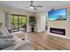 Comfortable living room features a modern fireplace, ceiling fan, and sliding doors to a balcony with outdoor seating at 19505 Quesada Ave # Vv201, Port Charlotte, FL 33948