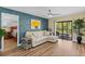 Comfortable living area with a modern sofa, a decorative blue wall, and sliding glass doors to a private balcony at 19505 Quesada Ave # Vv201, Port Charlotte, FL 33948