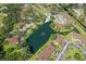 Community aerial view with a swimming pool, parking areas, and a central pond, highlighting lush landscaping and tranquil setting at 19505 Quesada Ave # Vv201, Port Charlotte, FL 33948