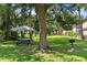 Enjoy community picnic area featuring a charcoal grill, umbrella-covered picnic table, mature trees, and well maintained lawn at 19505 Quesada Ave # Vv201, Port Charlotte, FL 33948