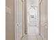 Hallway view of a well-lit, white bathroom with double closets and tiled floors at 2105 Deborah Dr, Punta Gorda, FL 33950