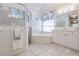 Bright bathroom with white vanity, soaking tub, and glass-enclosed shower at 2105 Deborah Dr, Punta Gorda, FL 33950