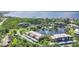 Community aerial view showcasing pond, tennis courts, beautiful landscaping and Gulf views at 23465 Harborview Rd # 214, Punta Gorda, FL 33980