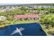 Overhead view of condos with lush greenery surrounding them and a lake with a water fountain feature at 23465 Harborview Rd # 214, Punta Gorda, FL 33980