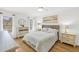 Bright bedroom with white walls, wood floors, a queen-sized bed, and an ensuite bathroom at 23465 Harborview Rd # 214, Punta Gorda, FL 33980