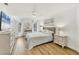 Bright bedroom with white walls, wood floors, a queen-sized bed, and an ensuite bathroom at 23465 Harborview Rd # 214, Punta Gorda, FL 33980
