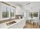 Bright kitchen featuring white countertops, gray backsplash, and an adjacent breakfast area at 23465 Harborview Rd # 214, Punta Gorda, FL 33980