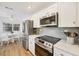 Updated kitchen with stainless steel appliances, white cabinetry, and an adjacent breakfast nook at 23465 Harborview Rd # 214, Punta Gorda, FL 33980