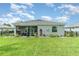 Lush backyard featuring well-maintained lawn, landscaping, and screened-in patio at 24348 Nicobar Ln, Punta Gorda, FL 33955