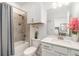 Stylish bathroom boasts a tiled shower, white vanity with sink, and floral decor at 24348 Nicobar Ln, Punta Gorda, FL 33955