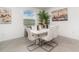 Dining room featuring neutral walls, tile floors, a modern table, and a view of the exterior through a window at 24348 Nicobar Ln, Punta Gorda, FL 33955