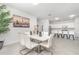 Dining area featuring neutral walls, tile floors, a modern table, and open view to the kitchen with bar seating at 24348 Nicobar Ln, Punta Gorda, FL 33955