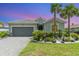 Beautiful one-story home featuring a well-maintained front yard with a two car garage and brick paver driveway at 24348 Nicobar Ln, Punta Gorda, FL 33955