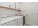Bright laundry room with white appliances, cabinetry, and a convenient hanging rack at 24348 Nicobar Ln, Punta Gorda, FL 33955
