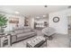 Open-concept living space with neutral walls, tile floors, modern seating, and views into the kitchen and dining areas at 24348 Nicobar Ln, Punta Gorda, FL 33955