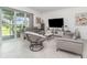 Living room featuring neutral walls, tile floors, modern furniture, and views of the outdoor space at 24348 Nicobar Ln, Punta Gorda, FL 33955