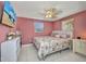 Comfortable bedroom featuring a ceiling fan, television and view of outside at 25082 Harborview Rd, Punta Gorda, FL 33980
