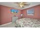 Cozy bedroom featuring a ceiling fan, TV, and a comfortable-looking floral bedspread at 25082 Harborview Rd, Punta Gorda, FL 33980