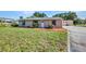 This single-story home features a lush green lawn, small garden, and charming curb appeal at 25082 Harborview Rd, Punta Gorda, FL 33980