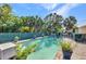 Large swimming pool in backyard with brick pavers, mature trees, and ample space for outdoor enjoyment at 25082 Harborview Rd, Punta Gorda, FL 33980