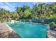 Sparkling pool surrounded by lush tropical landscaping, creating a serene and private backyard oasis at 25082 Harborview Rd, Punta Gorda, FL 33980