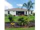 The backyard features manicured landscaping, a well-maintained lawn, and a screened-in patio at 25224 Lahore Ln, Punta Gorda, FL 33983