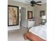 Neutral toned main bedroom featuring decorative ceiling fan, chest of drawers, and large painting on the wall at 25224 Lahore Ln, Punta Gorda, FL 33983