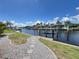 Backyard waterfront view with a gravel path, boat dock, and lift at 2526 Brazilia Ct, Punta Gorda, FL 33950