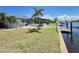 Backyard view showing lawn, foliage, and waterfront dock at 2526 Brazilia Ct, Punta Gorda, FL 33950