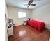 A cozy bedroom with ceiling fan, hardwood floors, and bright window for natural light at 2526 Brazilia Ct, Punta Gorda, FL 33950