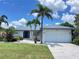 Charming home with well-manicured lawn and mature palm trees, showcasing curb appeal at 2526 Brazilia Ct, Punta Gorda, FL 33950