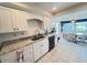Bright kitchen featuring white cabinets, granite countertops, and a view to a dining nook at 2526 Brazilia Ct, Punta Gorda, FL 33950