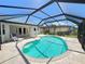 Inviting in-ground pool surrounded by a screened enclosure and lush landscaping at 2526 Brazilia Ct, Punta Gorda, FL 33950