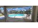 Enclosed pool with beautiful view of canal, nearby homes and blue skies and palm trees at 2526 Brazilia Ct, Punta Gorda, FL 33950