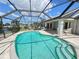 Beautiful in-ground pool with screened enclosure and patio seating area at 2526 Brazilia Ct, Punta Gorda, FL 33950