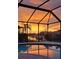 Stunning sunset view from a screened-in pool overlooking the serene canal at 2526 Brazilia Ct, Punta Gorda, FL 33950