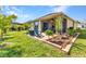 Backyard featuring a well-maintained lawn, mature landscaping, and a charming outdoor patio with seating at 25272 E Lenox Cir, Punta Gorda, FL 33950