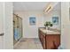 Bright bathroom featuring a double vanity sink and glass door shower enclosure at 25272 E Lenox Cir, Punta Gorda, FL 33950