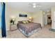 Bright bedroom features neutral walls, ceiling fan, and a colorful paisley bedspread at 25272 E Lenox Cir, Punta Gorda, FL 33950