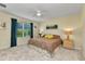 Bright bedroom with a ceiling fan, comfortable bed, and large windows at 25272 E Lenox Cir, Punta Gorda, FL 33950
